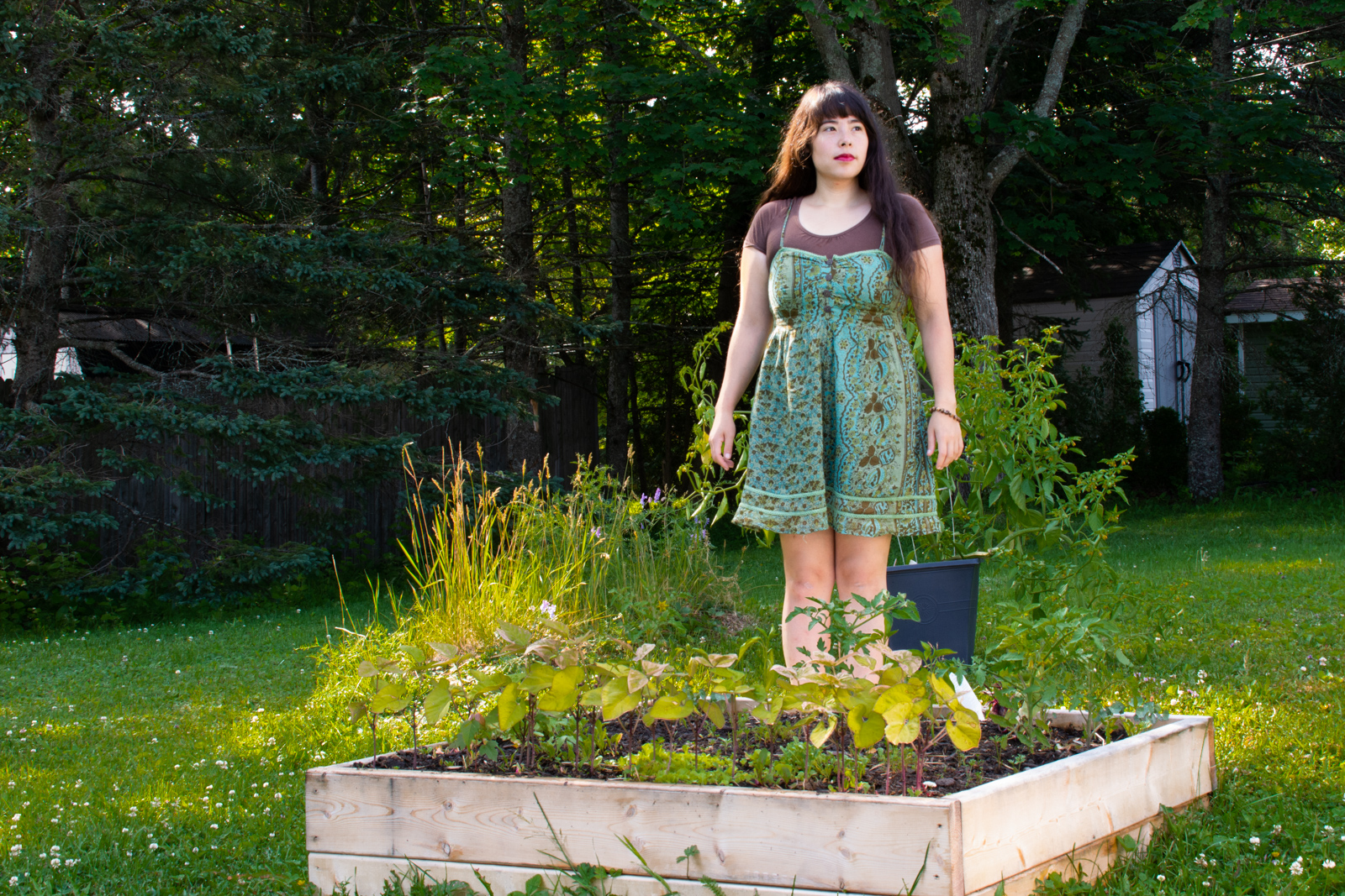 woman standing in her yard behind a small garden box