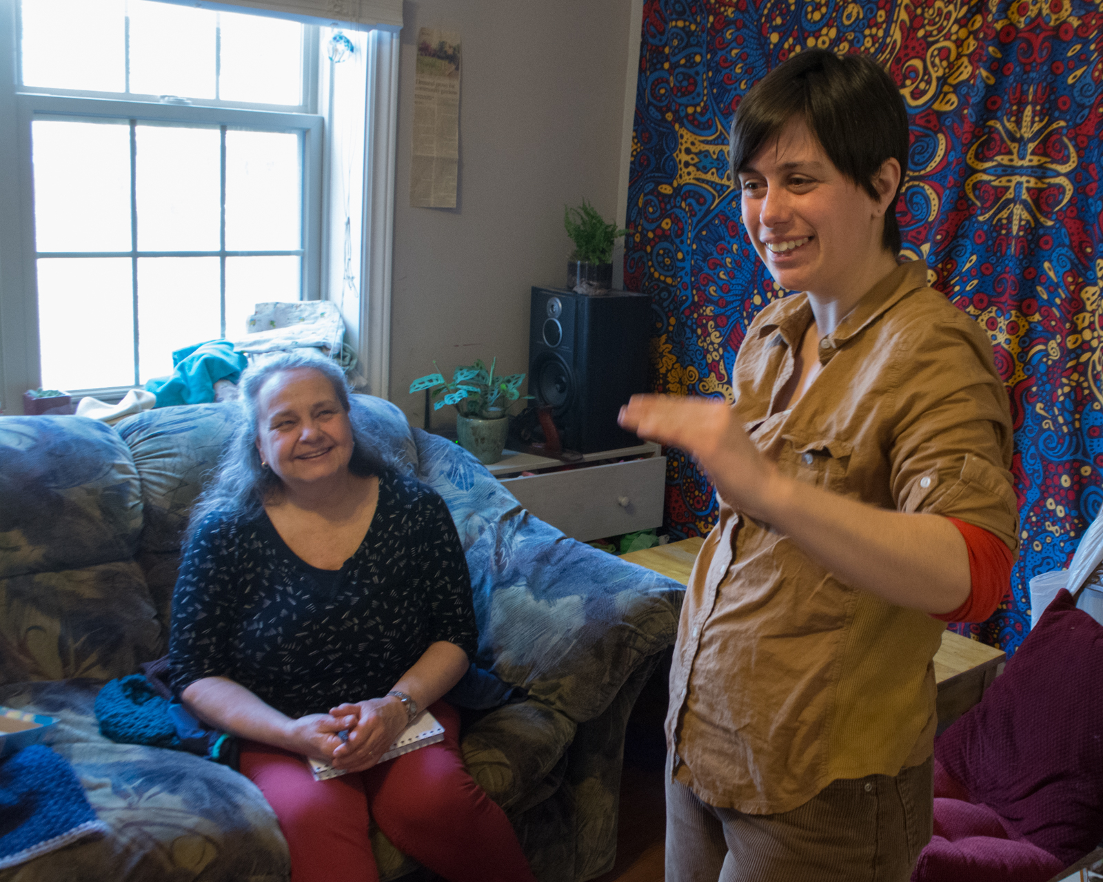 woman talking in her living room with an older woman